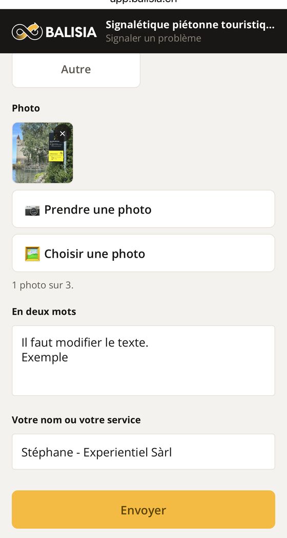Écran de signalement sur un téléphone : une photo du panneau, les boutons « Prendre une photo » et « Choisir une photo », et le champ de description