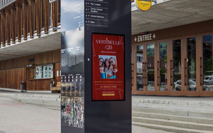 Totem à écran installé devant Espace Gruyère, à Bulle