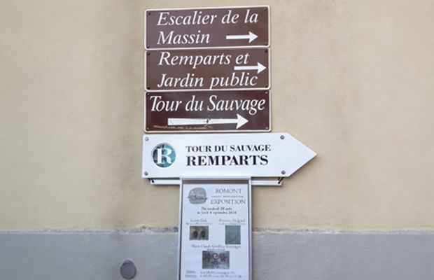 Panneaux superposés sur une façade, certains décolorés et obsolètes
