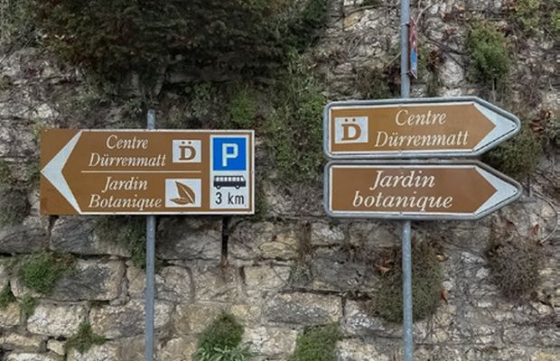 Signaux directionnels de styles et d'époques différents empilés sur un même poteau