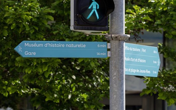 Indicateurs directionnels turquoise de Neuchâtel, annonçant le Muséum d'histoire naturelle à 6 minutes et la gare à 14 minutes